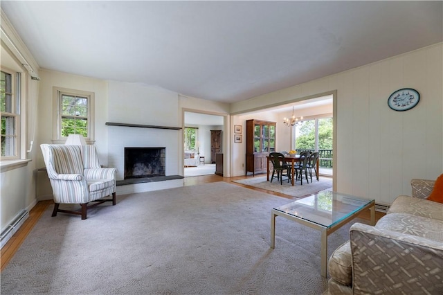 61 Bay View Rd, Charlestown, RI 02813 - living area with a chandelier, wood finished floors, a fireplace, and a baseboard radiator