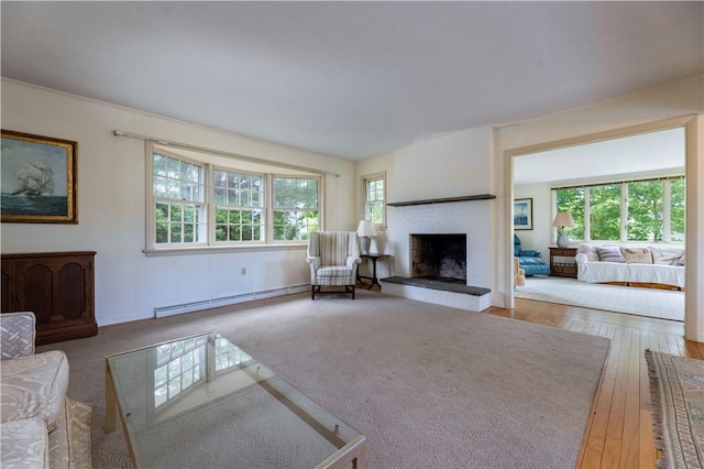 61 Bay View Rd, Charlestown, RI 02813 - living area with a baseboard radiator, plenty of natural light, a fireplace, and hardwood / wood-style flooring
