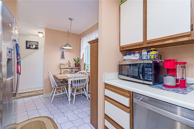 66 Girard Ave Unit 322, Newport, RI 02840 - kitchen featuring appliances with stainless steel finishes, light countertops, white cabinets, light tile patterned floors, and pendant lighting