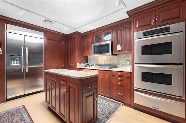 6 Lachance Ave, Warwick, RI 02889 - kitchen featuring stainless steel appliances, track lighting, light wood-style flooring, glass insert cabinets, and backsplash