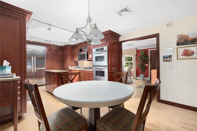 6 Lachance Ave, Warwick, RI 02889 - kitchen with built in appliances, wallpapered walls, light wood-style floors, light countertops, and a center island