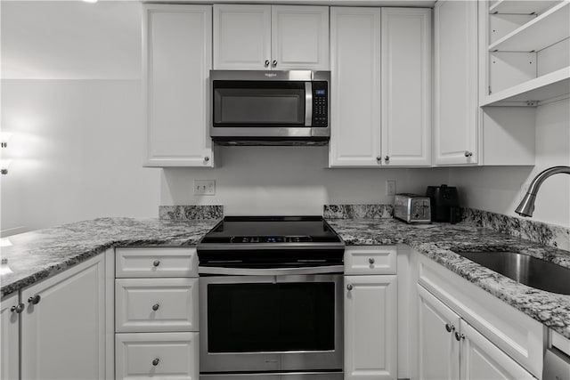 401 Bellevue Ave Unit 214, Newport, RI 02840 - kitchen featuring appliances with stainless steel finishes, white cabinetry, and light stone counters
