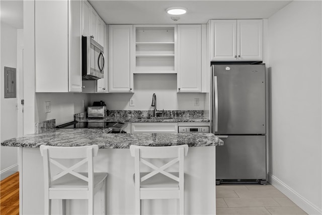 401 Bellevue Ave Unit 214, Newport, RI 02840 - kitchen featuring stainless steel appliances, electric panel, a peninsula, white cabinets, and stone counters
