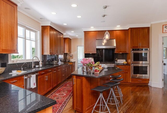 1003 Fort Getty Rd, Jamestown, RI 02835 - kitchen featuring stainless steel appliances, exhaust hood, dark wood finished floors, a kitchen island, and decorative backsplash