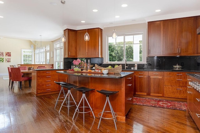 1003 Fort Getty Rd, Jamestown, RI 02835 - kitchen featuring dark wood-type flooring, a kitchen island, a breakfast bar, recessed lighting, and ornamental molding