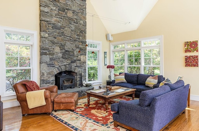 1003 Fort Getty Rd, Jamestown, RI 02835 - living room featuring light wood-type flooring, high vaulted ceiling, a wood stove, and plenty of natural light