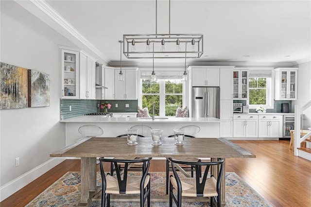 100 Algonquin Rd Unit 5, Narragansett, RI 02882 - dining area featuring plenty of natural light, wine cooler, crown molding, stairs, and wood finished floors