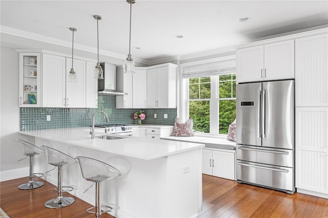 100 Algonquin Rd Unit 5, Narragansett, RI 02882 - kitchen featuring stainless steel fridge, wall chimney exhaust hood, a kitchen breakfast bar, light countertops, and white cabinetry