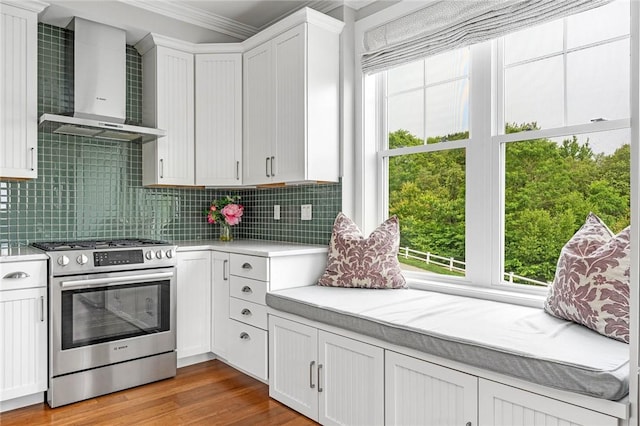 100 Algonquin Rd Unit 5, Narragansett, RI 02882 - kitchen with stainless steel range with gas cooktop, wall chimney range hood, light countertops, crown molding, and tasteful backsplash