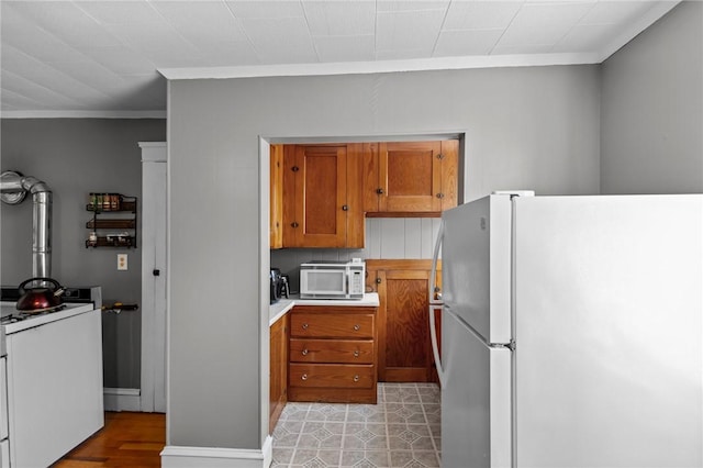 39 Owen Ave, Pawtucket, RI 02860 - kitchen featuring white appliances, brown cabinets, ornamental molding, and light countertops