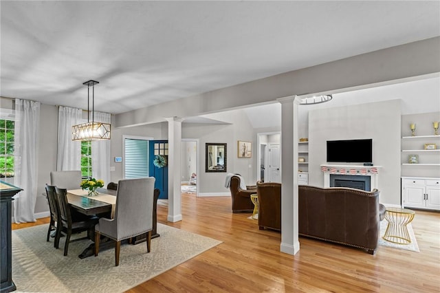 52 Pine Swamp Rd, Cumberland, RI 02864 - dining space with decorative columns, a fireplace, and light wood-type flooring