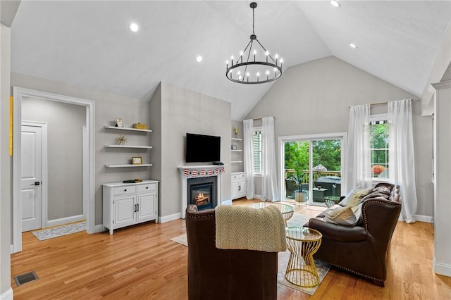 52 Pine Swamp Rd, Cumberland, RI 02864 - living area featuring a glass covered fireplace, a chandelier, high vaulted ceiling, light wood-style floors, and recessed lighting