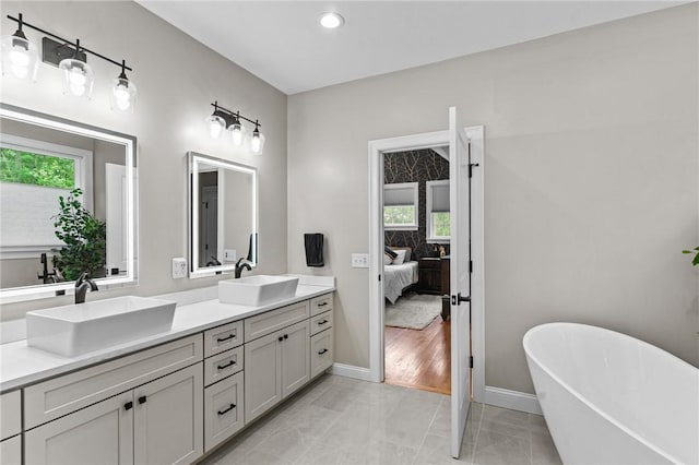 52 Pine Swamp Rd, Cumberland, RI 02864 - ensuite bathroom featuring double vanity, a soaking tub, marble finish floors, and recessed lighting
