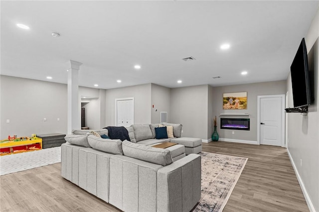 52 Pine Swamp Rd, Cumberland, RI 02864 - living area featuring light wood-style floors, recessed lighting, a glass covered fireplace, and ornate columns