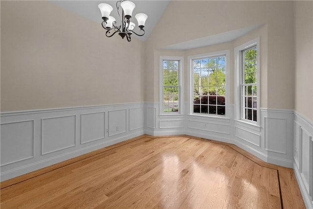 115 Read St, Attleboro, MA 02703 - unfurnished dining area featuring a chandelier, a wainscoted wall, lofted ceiling, light wood-style floors, and a decorative wall