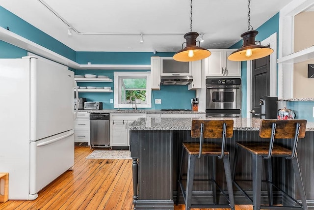 15 N St, Warwick, RI 02886 - kitchen with appliances with stainless steel finishes, track lighting, white cabinetry, and under cabinet range hood