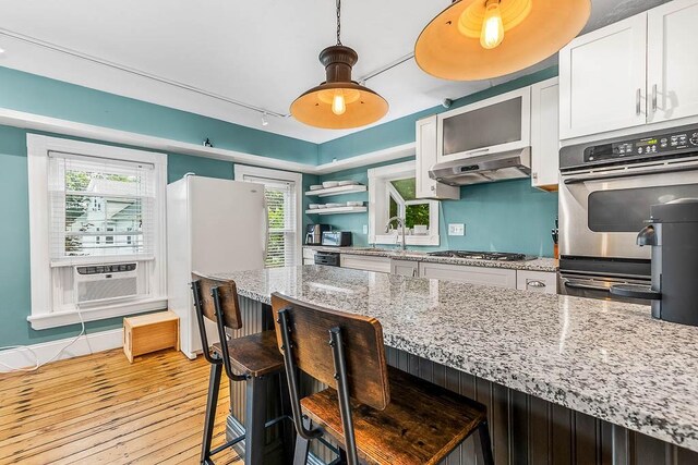 15 N St, Warwick, RI 02886 - kitchen with light wood-style flooring, cooling unit, a kitchen breakfast bar, and white cabinetry