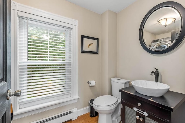 15 N St, Warwick, RI 02886 - half bathroom with a baseboard heating unit, vanity, and wood finished floors