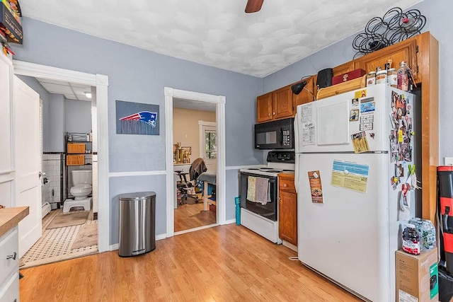15 N St, Warwick, RI 02886 - kitchen with white appliances, brown cabinets, light wood-type flooring, and light countertops