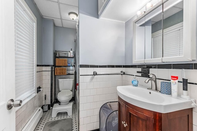 15 N St, Warwick, RI 02886 - bathroom with a baseboard heating unit, tile walls, vanity, tile patterned flooring, and wainscoting