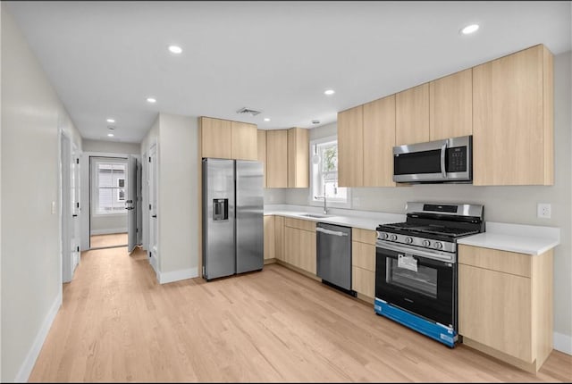 137 Stanwood St, Providence, RI 02907 - kitchen with stainless steel appliances, light brown cabinetry, light wood-style floors, light countertops, and recessed lighting