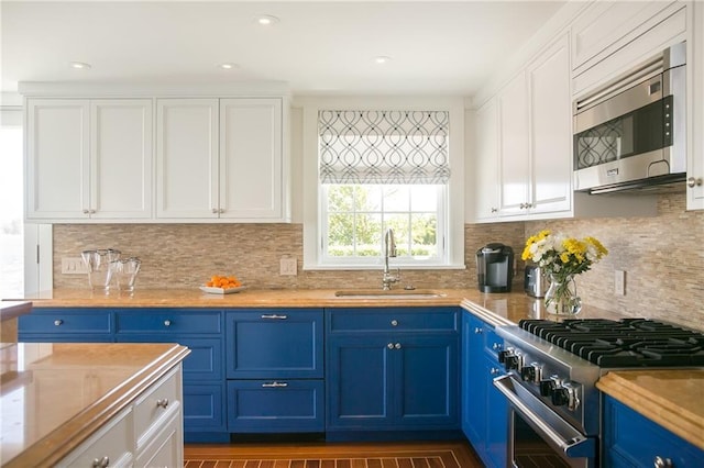 19 Defenders Row Unit 19, Newport, RI 02840 - kitchen with stainless steel appliances, blue cabinetry, white cabinets, decorative backsplash, and light countertops