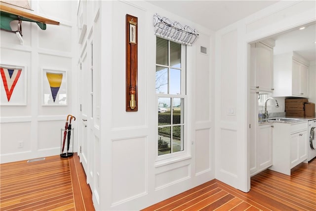19 Defenders Row Unit 19, Newport, RI 02840 - doorway featuring a decorative wall, washer / clothes dryer, and light wood-type flooring
