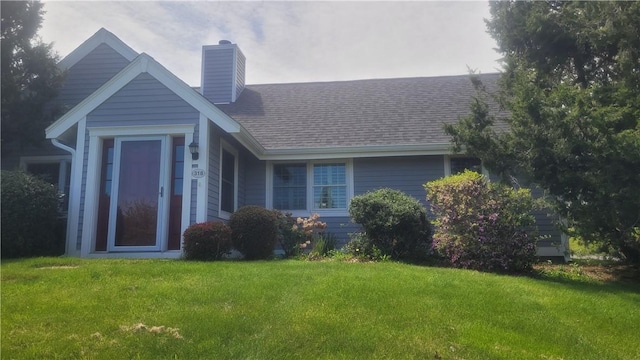 318 Corey Ln Unit 318, Middletown, RI 02842 - view of front of house featuring a chimney, a front lawn, and a shingled roof