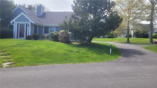 318 Corey Ln Unit 318, Middletown, RI 02842 - view of front of property with a front lawn, a chimney, driveway, and roof with shingles