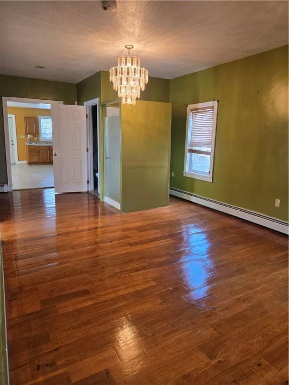133 Byfield St, Providence, RI 02905 - spare room featuring a baseboard heating unit, a chandelier, and wood finished floors