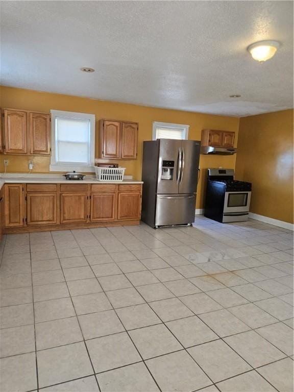 133 Byfield St, Providence, RI 02905 - kitchen with stainless steel appliances, under cabinet range hood, light countertops, a textured ceiling, and brown cabinets