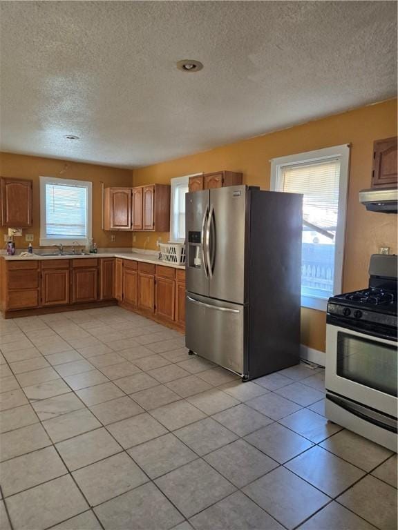 133 Byfield St, Providence, RI 02905 - kitchen with appliances with stainless steel finishes, light countertops, a textured ceiling, plenty of natural light, and range hood