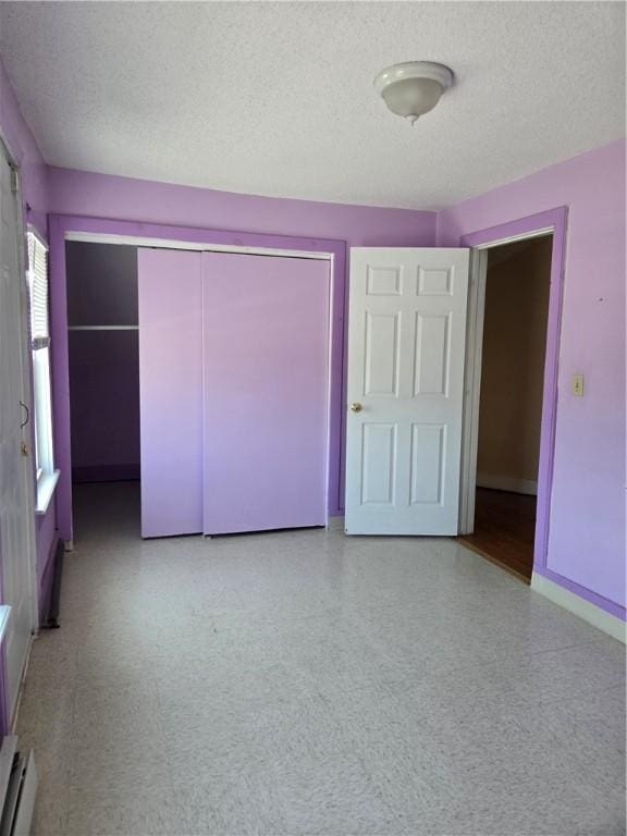 133 Byfield St, Providence, RI 02905 - unfurnished bedroom with baseboard heating, a closet, and a textured ceiling