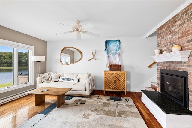 267 Fishing Cove Rd, North Kingstown, RI 02852 - living room with hardwood / wood-style floors, ceiling fan, and a brick fireplace