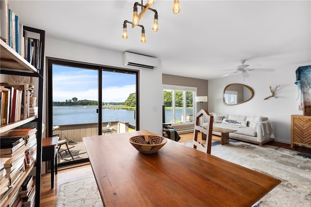 267 Fishing Cove Rd, North Kingstown, RI 02852 - dining area with a wall unit AC, a chandelier, ceiling fan, a water view, and light wood-style flooring