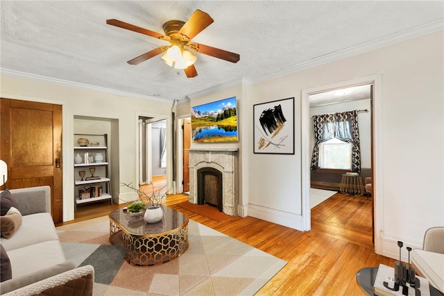 4 S Cornell Ave, Warren, RI 02885 - living room with light wood-style flooring, a fireplace, ornamental molding, a ceiling fan, and built in features