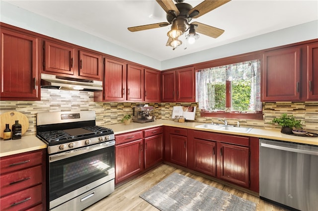 4 S Cornell Ave, Warren, RI 02885 - kitchen with stainless steel appliances, under cabinet range hood, dark brown cabinets, light countertops, and decorative backsplash