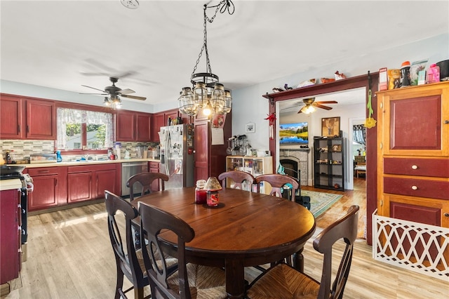 4 S Cornell Ave, Warren, RI 02885 - dining area featuring a ceiling fan, light wood-style flooring, and a fireplace