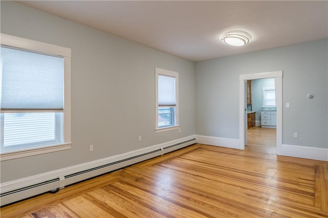 168 Waterman Ave, East Providence, RI 02914 - empty room with a baseboard heating unit and light wood-style floors