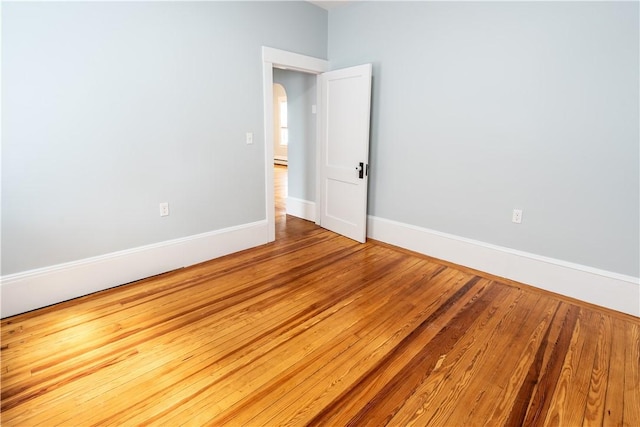168 Waterman Ave, East Providence, RI 02914 - spare room featuring wood finished floors, arched walkways, and baseboard heating