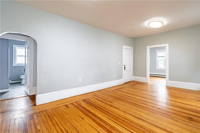 168 Waterman Ave, East Providence, RI 02914 - empty room featuring baseboard heating, light wood-style floors, and arched walkways