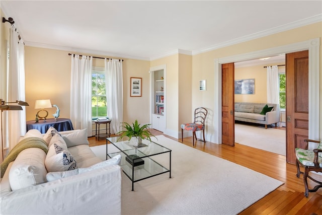 68 Grange Ave, Little Compton, RI 02837 - living room featuring wood finished floors, ornamental molding, healthy amount of natural light, and built in shelves