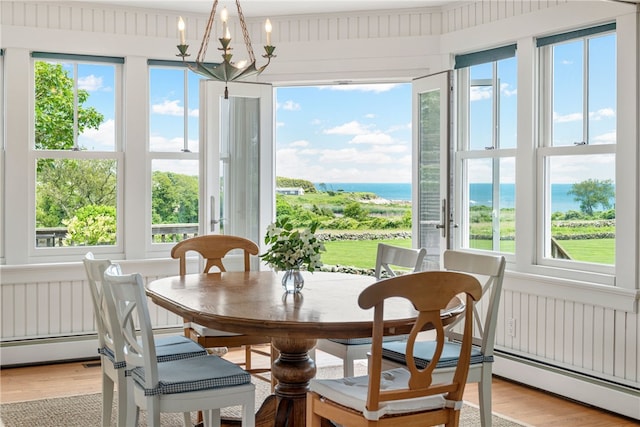 68 Grange Ave, Little Compton, RI 02837 - dining room with a water view, light wood-style floors, a chandelier, and a baseboard heating unit