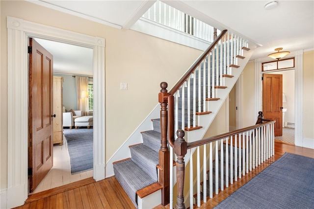 68 Grange Ave, Little Compton, RI 02837 - stairway featuring hardwood / wood-style floors, baseboard heating, and crown molding