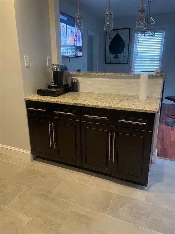 43 Toronto Ave, Providence, RI 02905 - kitchen featuring light stone counters, hanging light fixtures, light tile patterned flooring, and a peninsula