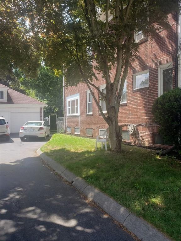 106 Langdon St, Providence, RI 02904 - view of side of home with brick siding, asphalt driveway, and a yard