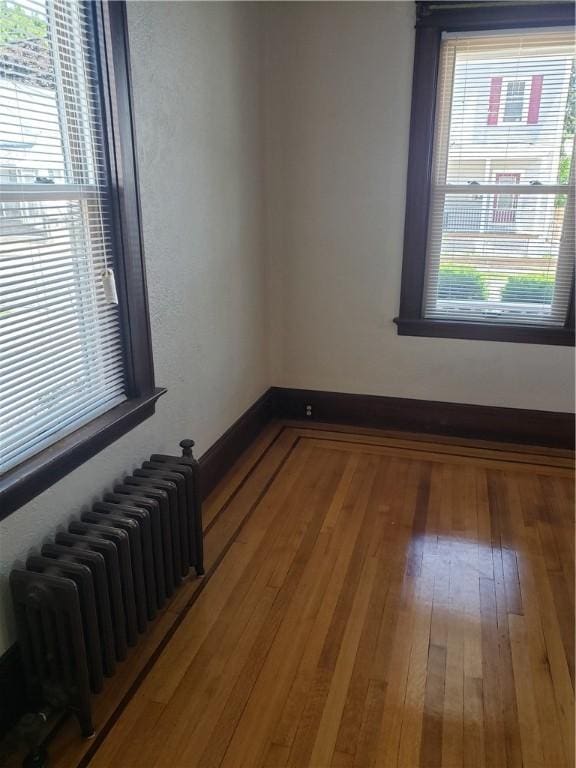 106 Langdon St, Providence, RI 02904 - empty room featuring radiator heating unit and hardwood / wood-style floors