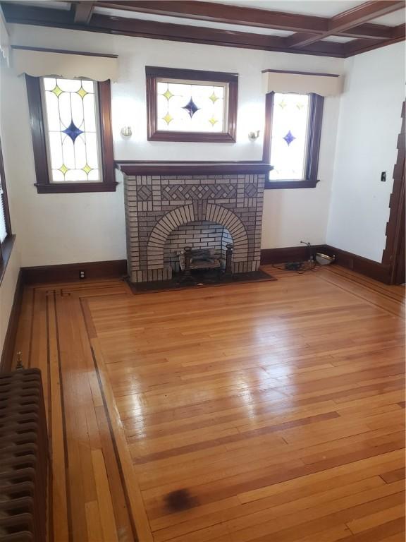 106 Langdon St, Providence, RI 02904 - living room with beamed ceiling, wood finished floors, coffered ceiling, and a brick fireplace