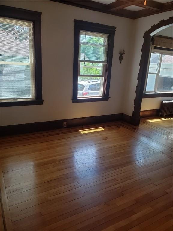 106 Langdon St, Providence, RI 02904 - spare room with hardwood / wood-style floors, arched walkways, and radiator