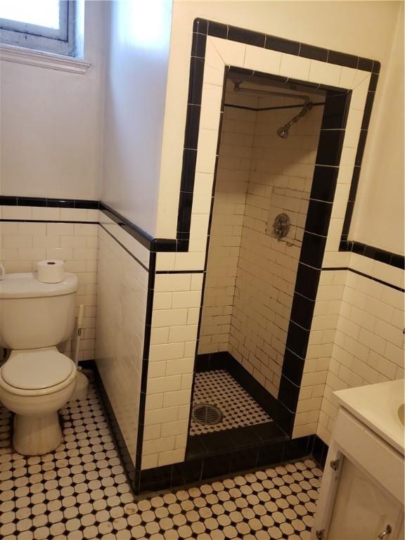 106 Langdon St, Providence, RI 02904 - bathroom with tile walls, tiled shower, wainscoting, vanity, and tile patterned floors